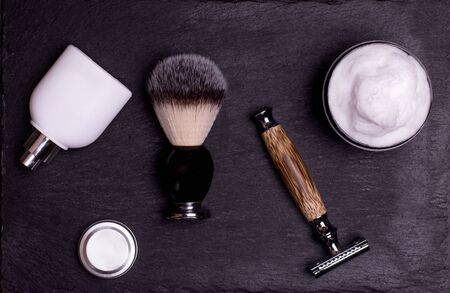 Razor, brush, perfume, balsam and shaving foam on a black background.の写真素材