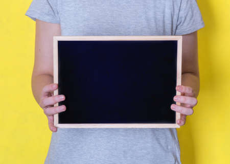 woman holding blank black chalkboardの写真素材