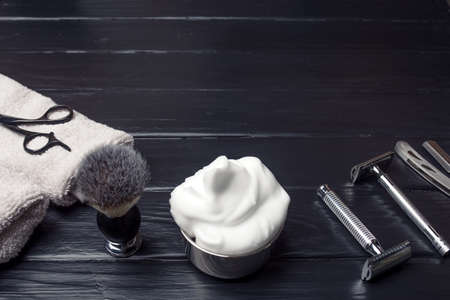 Razors, brush, towels and foam  on a wood background.の写真素材