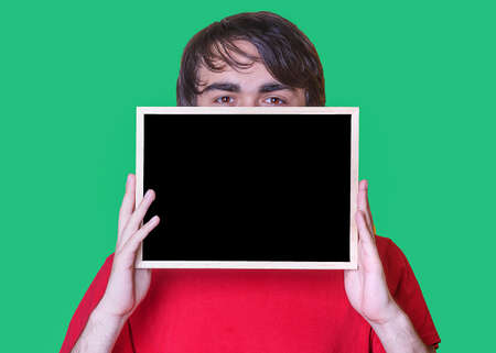 A young man holding  Mockup of   chalkboard on green backgroundの写真素材