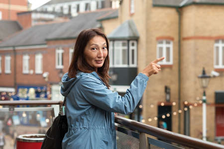 Asian woman in a blue coat walking around Europe cityの写真素材