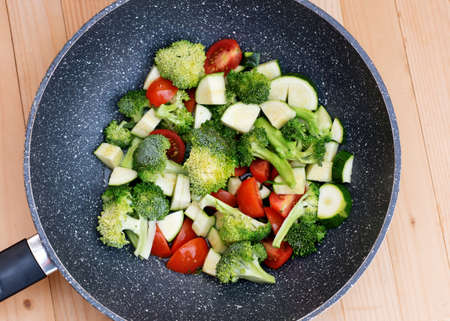 Green vegetables, broccoli, zucchini, tomatoes in a VOC panの写真素材