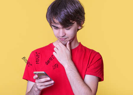 A young man in a red shirt chatting and living on the phoneの写真素材