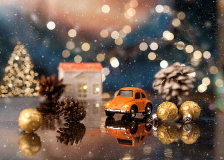 Toy car on on the icy surface among Christmas decoration on the background of bokehの写真素材