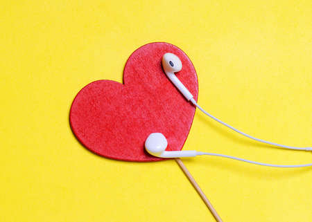 red heart and headphones on a yellow backgroundの写真素材