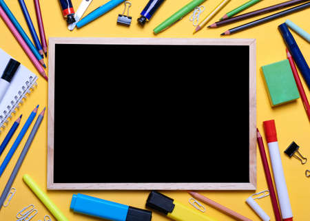Mockup of Black board, pencils, highlighters, chalks on yellow backgroundの写真素材