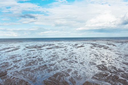 Sand beach, sea and cloudy blue sky in England in sunny day