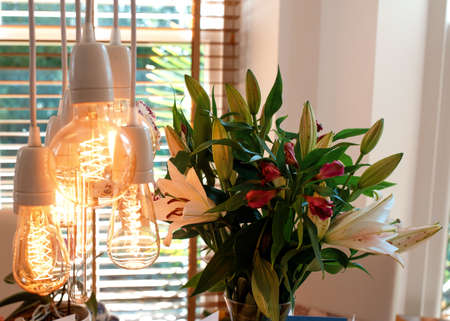 Bouquet of lilies on the table and a lampの写真素材