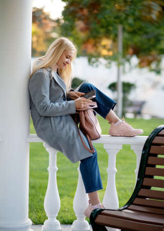 woman sitting on a bench and checking  phoneの写真素材