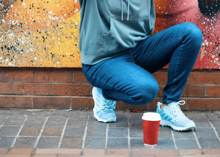 woman sitting near the wall and drinking coffee