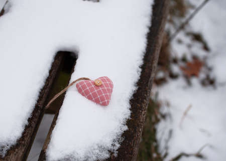 heart in snow on a bench in winterの写真素材
