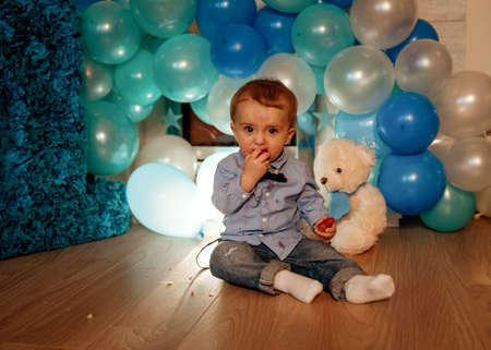 baby child with balloons having his birthday against blue balloonsの写真素材