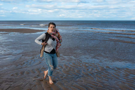 Woman in jeans walking  on seaside  in great dayの写真素材