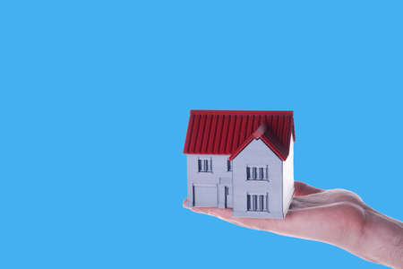 Big house in hand on blue backgroundの写真素材