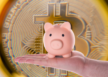 hand holding piggy bank on blurred bitcoin  backgroundの写真素材