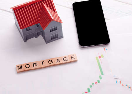 A phone and house on mortgage chart and title mortgageの写真素材