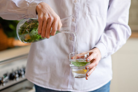 woman pouring fresh water into a glass from a decanter
