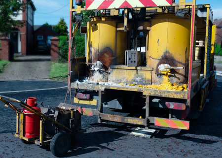 White lining machine preparing road paint by heating to high temperature and melting it for...