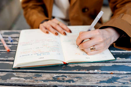 woman holding a penand notebook  in the cafe  on the tableの写真素材
