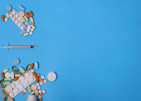 pills, vitamins and disposable syringe on blue backgroundの写真素材
