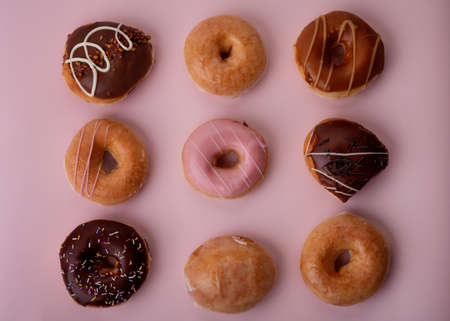 a collection of various donuts on a pink backgroundの写真素材