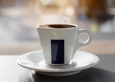 cup of coffee   on the table in cafe against window in sunny dayの写真素材