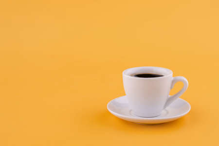 cup of americano coffee on a yellow background. Space for text.の写真素材