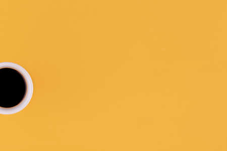 cup of americano coffee on a yellow background. Space for text.の写真素材