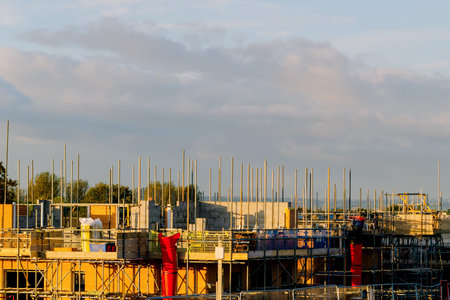 New residential house under construction and scaffolds erected around it to provide safe working...