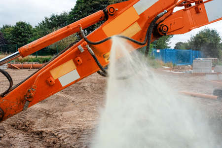An incident in construction as a hydraulic hose on excavator split and liquid started sprinkling around under high pressureの写真素材