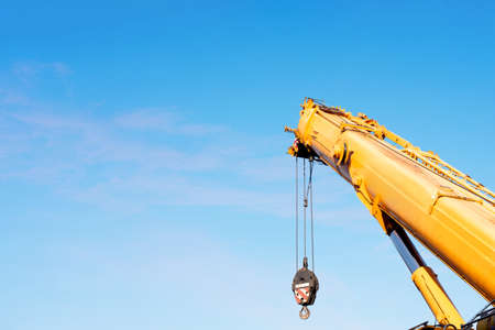 Mobile crane rising the main boom up ready for lifting operation on the building siteの写真素材