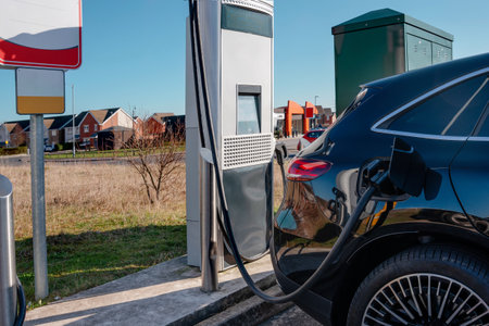 Electric vehicle charging station and a car connected to it to recharge. Time to rechargeの写真素材