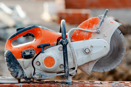 Close up of petrol concrete saw on top of brick wall on construction siteの写真素材