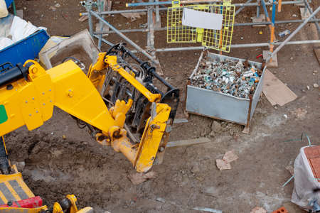 Telehandler on construction site moving heavy steel box full of scaffolding partsの写真素材