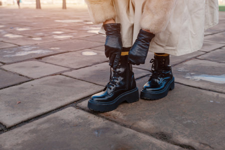 feet of a woman in a black shoes  on the city street on cold dayの写真素材