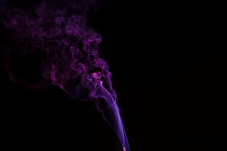 incense stick with smoke against black backgroundの写真素材