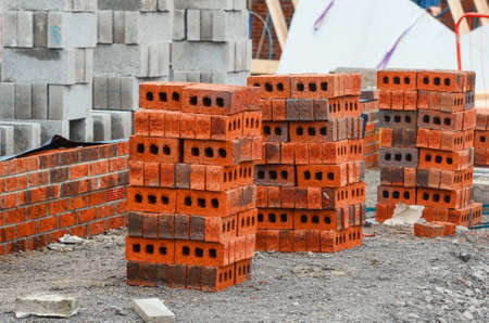 Red bricks and concrete blocks delivered on construction site and placed next to place of work ready for bricklayersの写真素材