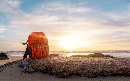 Orange rucksack, backpack   on the seaside against the sea at sunset. Travel concept.の写真素材