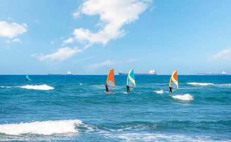 Enjoying extreme windsurfing and ocean waves on a hot sunny day. water sports conceptの素材