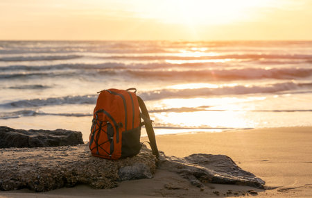 Orange rucksack, backpack   on the seaside against the sea at sunset. Travel concept.の写真素材