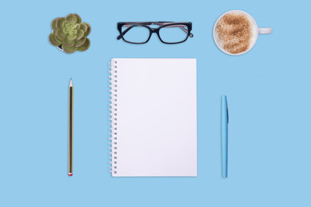 cup of coffee, notebook,  pen, glasses and white empty sheet on green background.  Flat Lay with no people. View  from the top. The financial checksの写真素材
