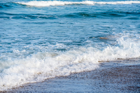 Sand beach, sea and cloudy blue sky at sunsetの写真素材