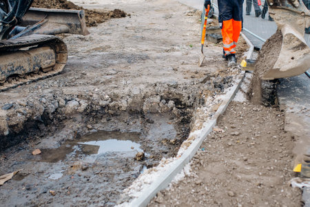 A new footpath is under construction as builders bring stone, levelling and compacting itの写真素材