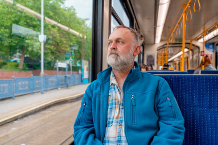 portrait of a dreamy bearded man in a blue jacket on a bus. Lifestyle conceptの写真素材