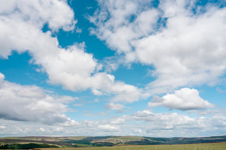 white cirrus, feathery clouds against spring bright blue cloudy sky on sunny day in Englandの写真素材
