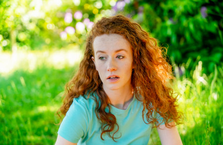 Closeup portrait of a young happy woman with red curly hairの写真素材
