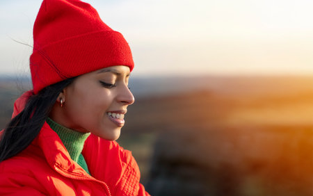 Portrait of young smiling beautiful woman tourist with backpack hiking and enjoying mountains landscape at sunset in England. A trip to the mountains with a backpack toned imageの写真素材