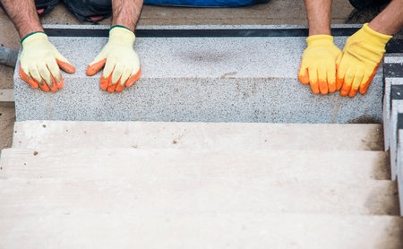 Concrete steps under construction as a team of builders install heavy concrete blocksの写真素材
