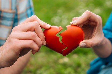 couple holding joining splitting two halves of broken heart Love divide happiness break upの写真素材