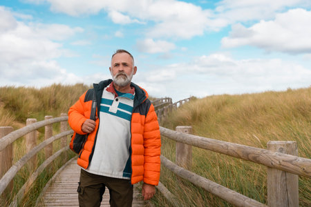 happy bearded man with reaching backpack destination on seaside on warm Autumn dayの写真素材
